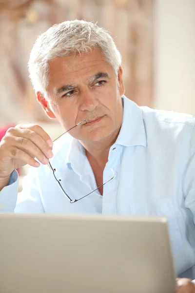 Senior man in front of laptop computer — Stock Photo, Image