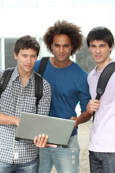 Группа студентов с ноутбуком — стоковое фото