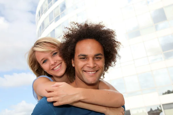 Ungt par gör piggyback utsidan — Stockfoto