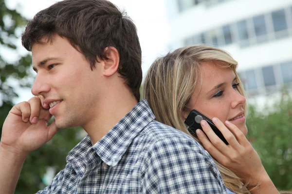 Молодая пара студентов с мобильным телефоном — стоковое фото
