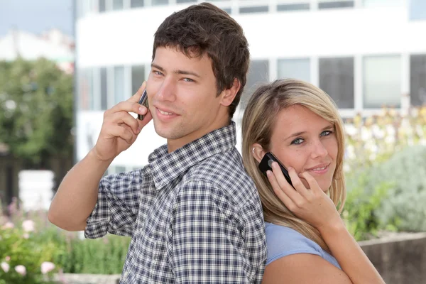 Jovem casal de estudantes com telefone celular — Fotografia de Stock