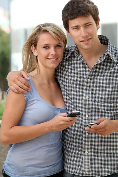 Молодая пара студентов с мобильным телефоном — стоковое фото
