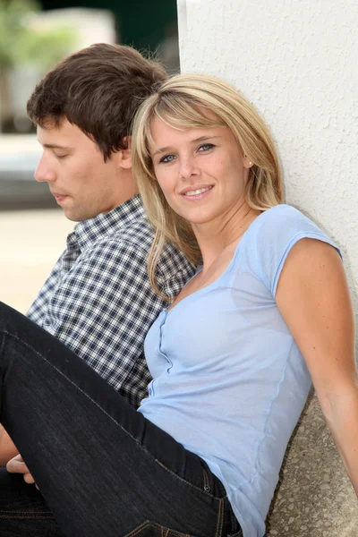 Jovem casal sentado no pátio do campus — Fotografia de Stock