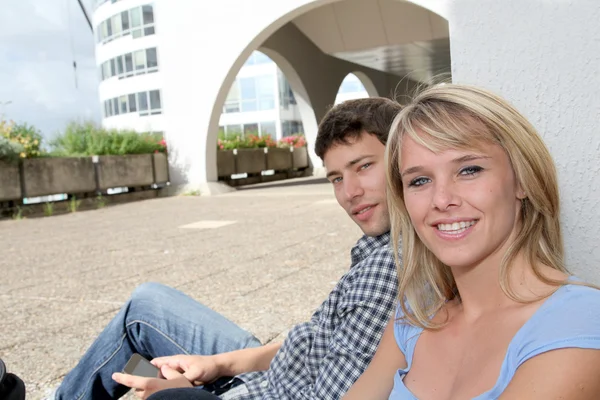 Junges Paar sitzt auf dem Campus-Hof — Stockfoto