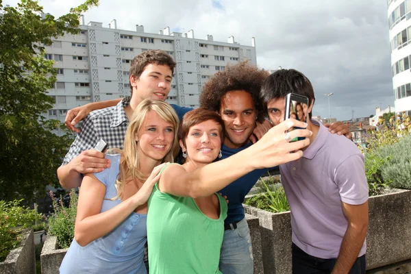 Grupo de amigos tomando fotos con teléfono móvil — Foto de Stock