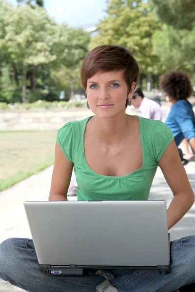 Estudiante con computadora portátil en el parque universitario — Foto de Stock
