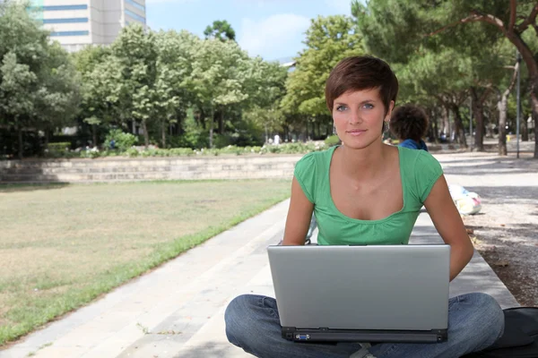 Студент з ноутбуком в парку коледжів — стокове фото