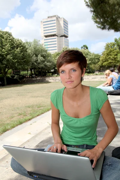 Студент с ноутбуком в студенческом парке — стоковое фото