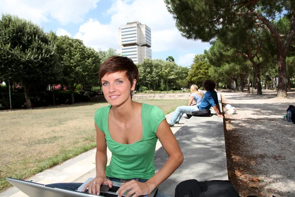 Estudante com computador portátil no parque universitário — Fotografia de Stock