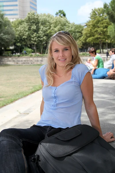 Beautiful blond woman sitting in a par — Stock Photo, Image