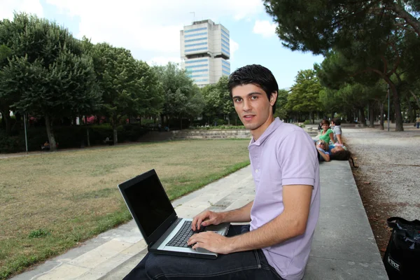 Student med bärbar dator i college park — Stockfoto