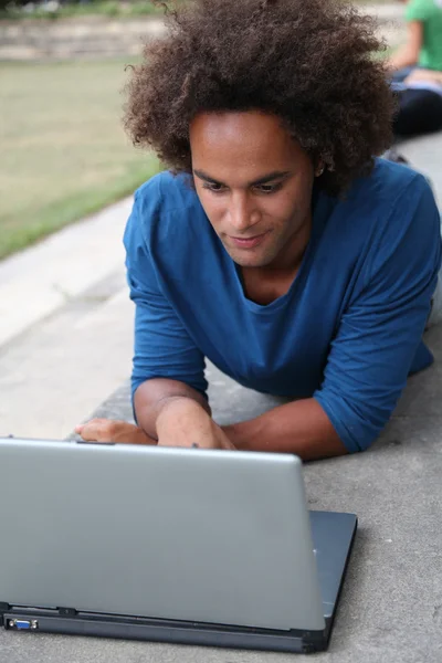 Student met laptopcomputer in college park — Stockfoto