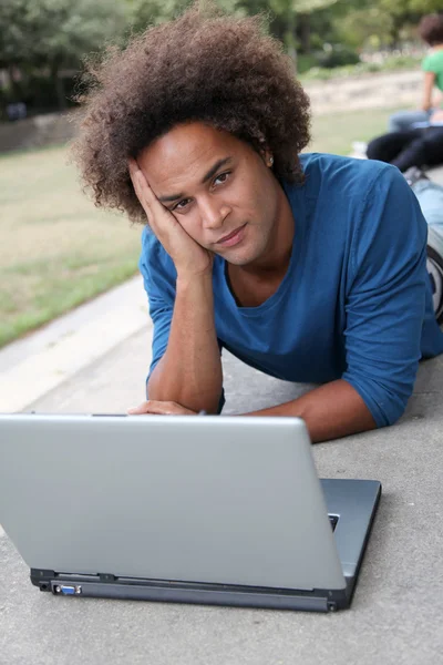 Студент з ноутбуком в парку коледжів — стокове фото