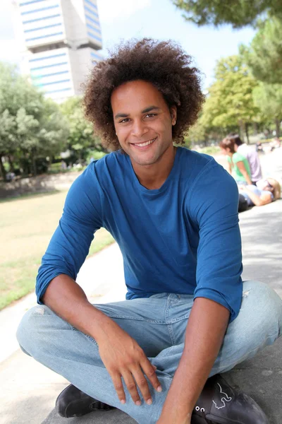 Jonge man zit in een park — Stockfoto