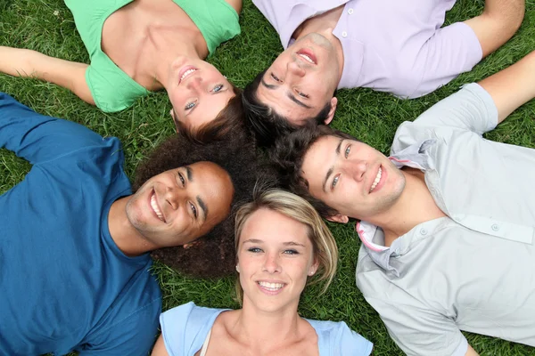 Group of friends laying down in park — Stock Photo, Image