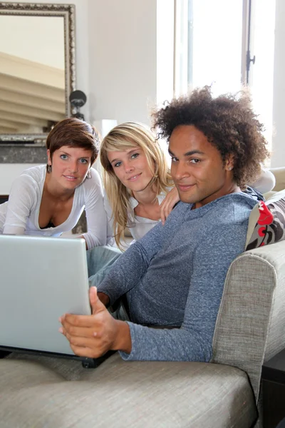 Group of friends sitting with laptop computer — Stock Photo, Image