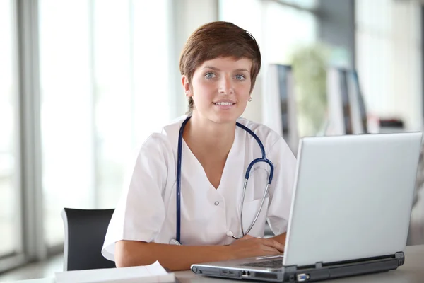 Hermosa enfermera delante de la computadora portátil —  Fotos de Stock
