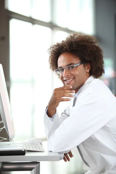 Молодой врач работает за компьютером — стоковое фото