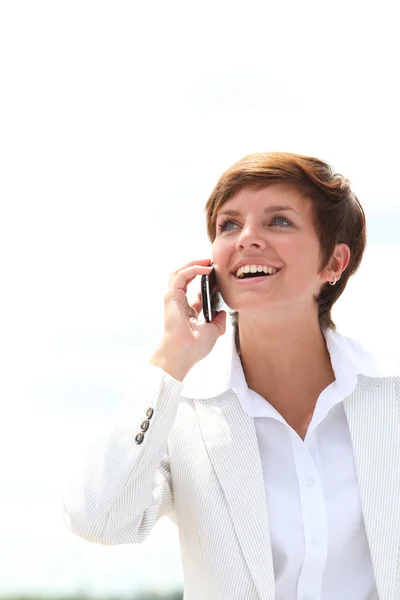 Улыбающаяся деловая женщина разговаривает по телефону — стоковое фото