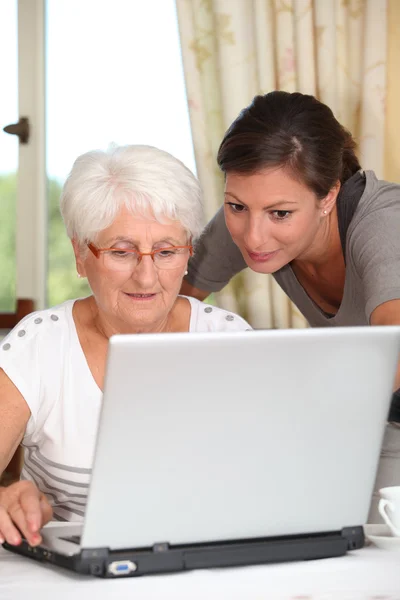 Пожилая женщина учится пользоваться компьютером — стоковое фото