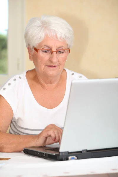 コンピューターを使用する方法を学ぶ高齢者の女性 — ストック写真