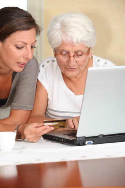 Starsza kobieta i młoda kobieta, zakupy w Internecie — Zdjęcie stockowe