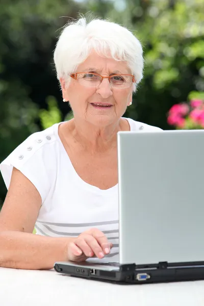 Ηλικιωμένη γυναίκα με φορητό υπολογιστή — Φωτογραφία Αρχείου