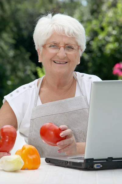 Mulher idosa com cesto de legumes frescos — Fotografia de Stock