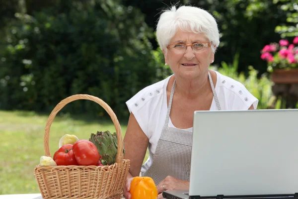 Ηλικιωμένη γυναίκα με καλάθι με φρέσκα λαχανικά — Φωτογραφία Αρχείου