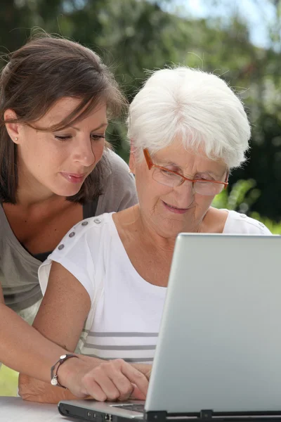 老年妇女和年轻女子在互联网上冲浪 — 图库照片
