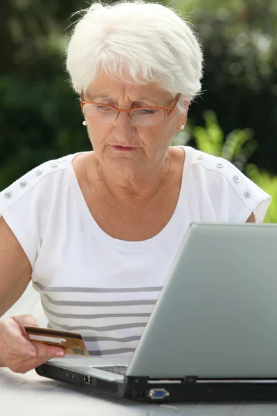 Пожилая женщина покупает онлайн — стоковое фото