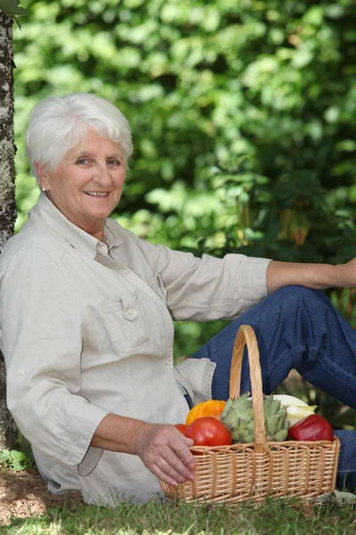 Yaşlı kadın ile sebze sepeti — Stok fotoğraf