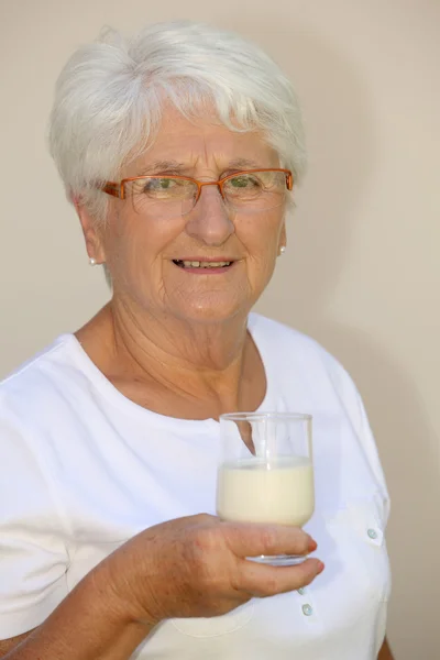 Elderly woman drinking milk — Stock Photo, Image