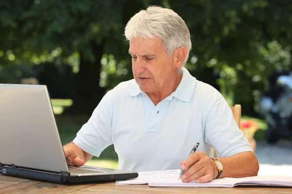 Hombre mayor con ordenador portátil — Foto de Stock