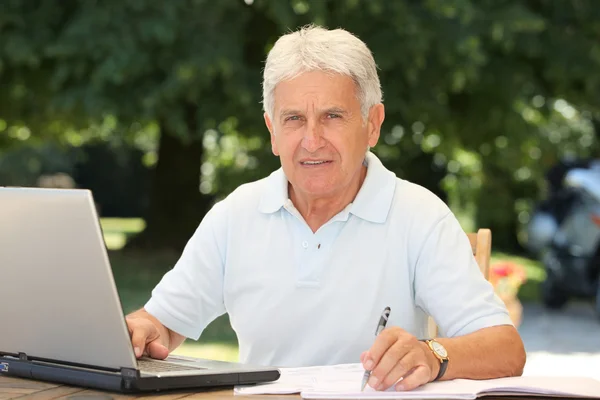 Senior man med bärbar dator — Stockfoto