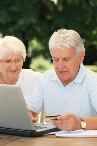 Старшая пара делает онлайн покупки — стоковое фото