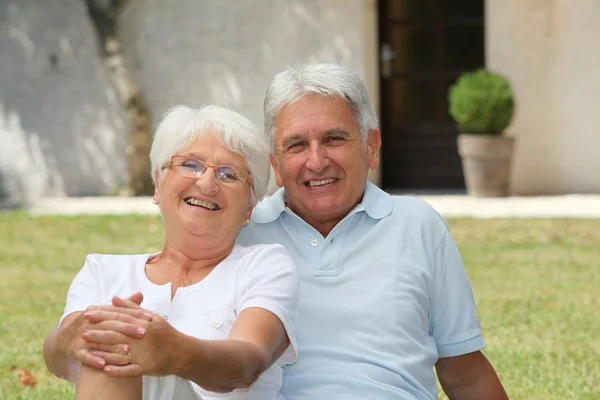 Seniorenpaar sitzt vor einem Haus — Stockfoto