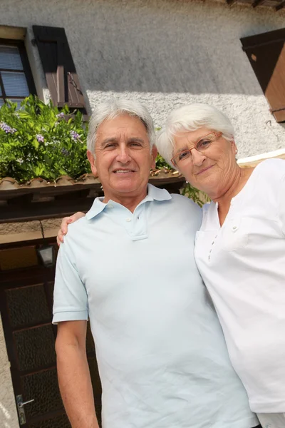 Старша пара сидить перед будинком — стокове фото