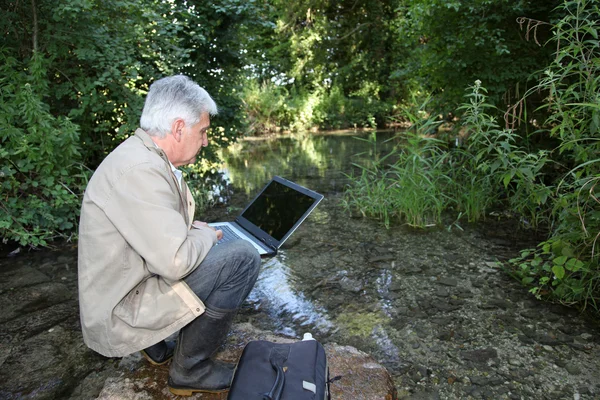 Biologist testing quality of stream water — Stock Photo, Image