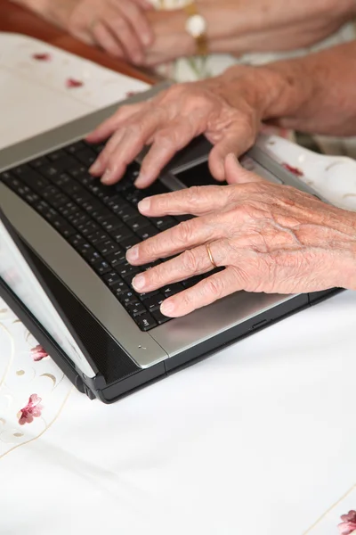Eldelry person hands on computer desk — Stock Photo, Image