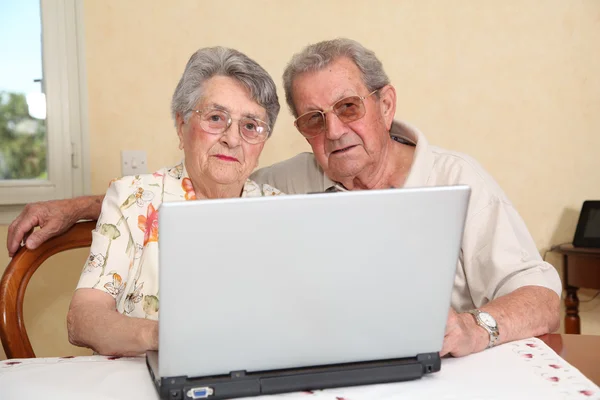 Пожилые люди с ноутбуком — стоковое фото