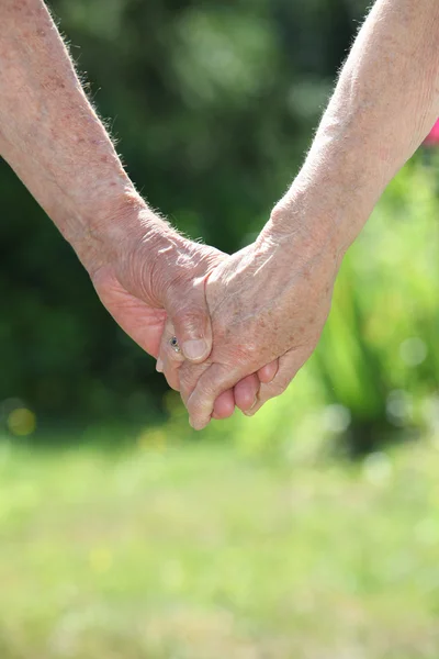 Äldre par som håller varandra i handen — Stockfoto