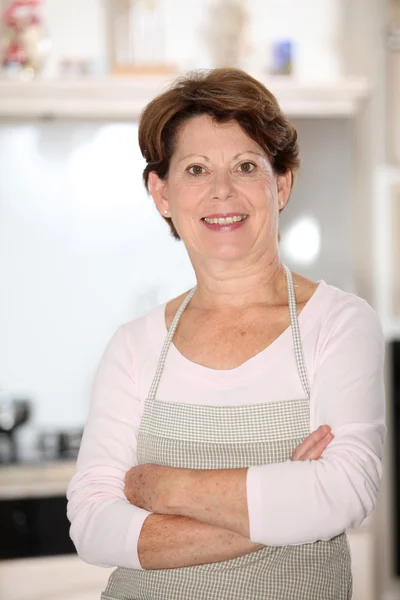 Senior woman standing in kitchen — Stock Photo, Image