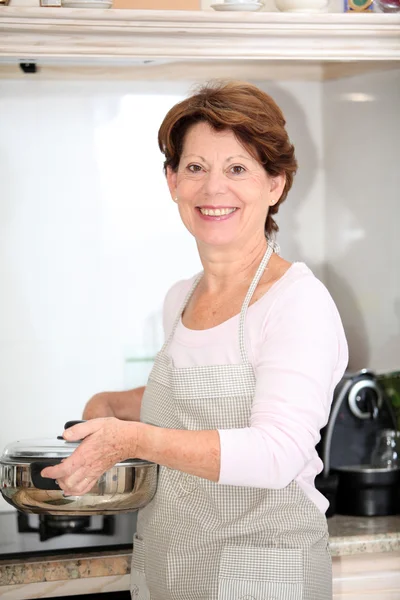 Seniorin steht in Küche — Stockfoto