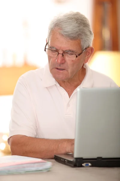 Hombre mayor haciendo declaración de impuestos en Internet — Foto de Stock