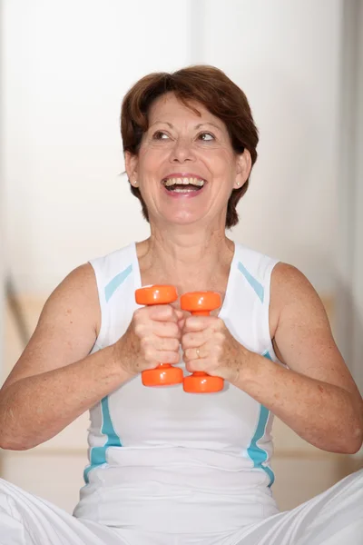 Äldre kvinna lyfta vikter — Stockfoto