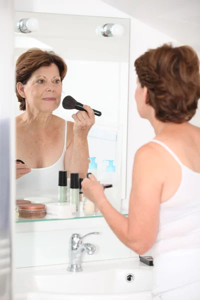 Starší žena dávat make-up — Stock fotografie
