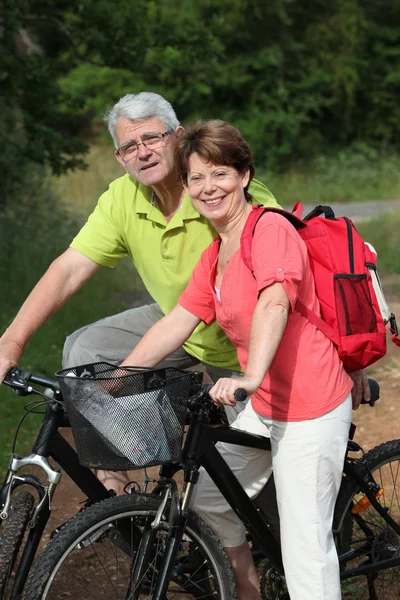 Vedoucí dvojice jedoucí na kole v přírodě — Stock fotografie