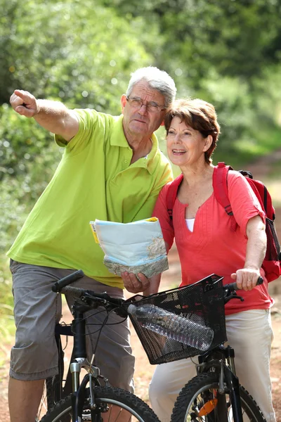 Senior couple riding bicycle in countryside — Stock Photo, Image