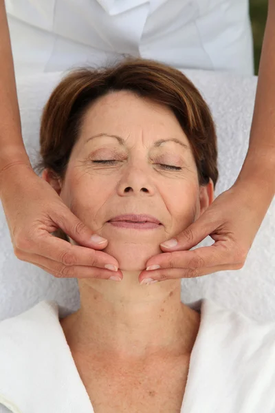 Mulher sênior na cama de massagem — Fotografia de Stock